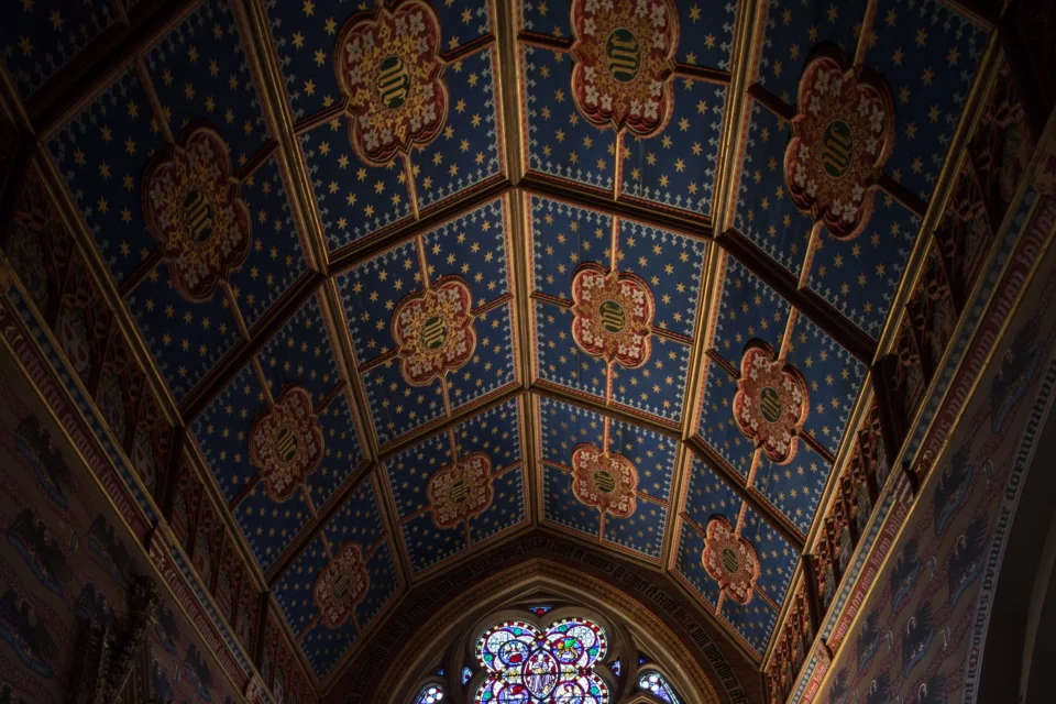 Ceiling painted dark blue with stars and red quatrefoil shapes in the centre of each panel.
