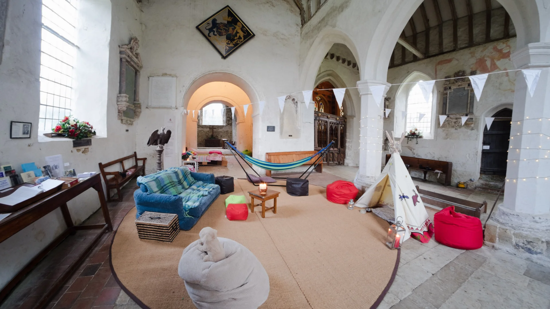 Church interior including sofa, children's play tipi and hammock