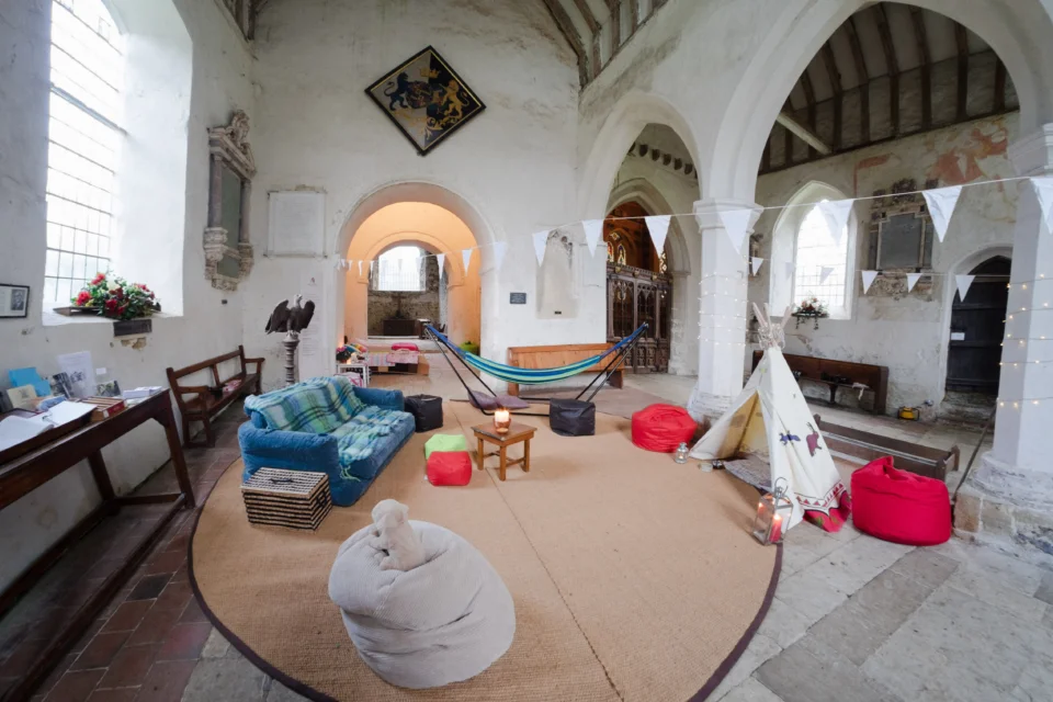 Church interior including sofa, children's play tipi and hammock
