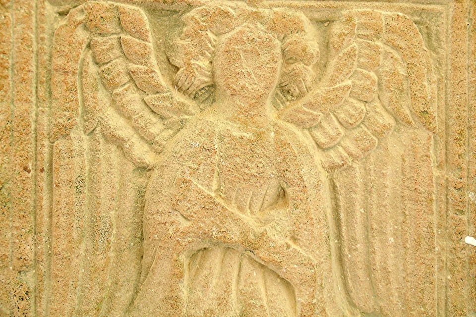Incised sand stone showing angel holding a document