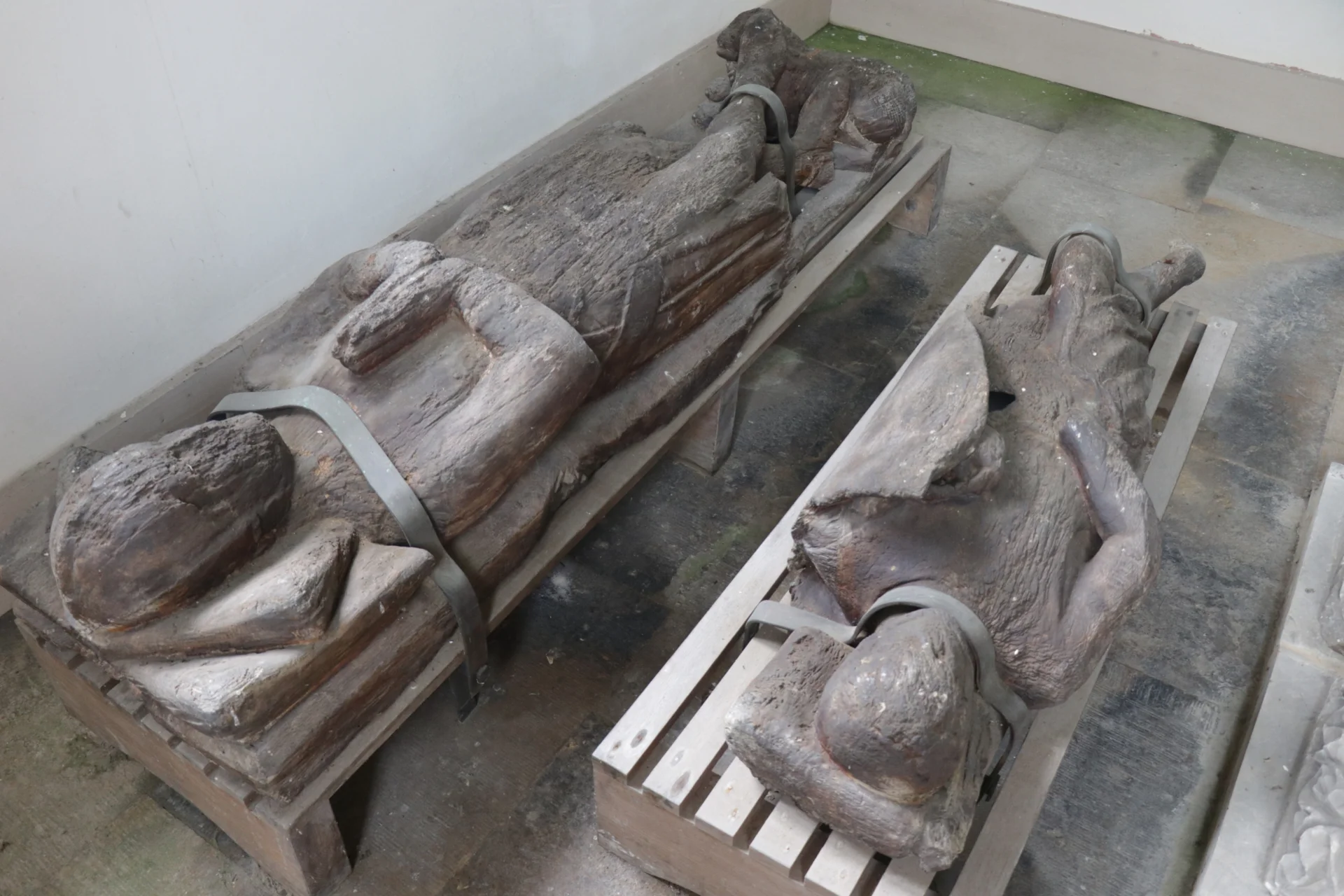 Timber Medieval effigies one with shield and one with hands in prayer position.