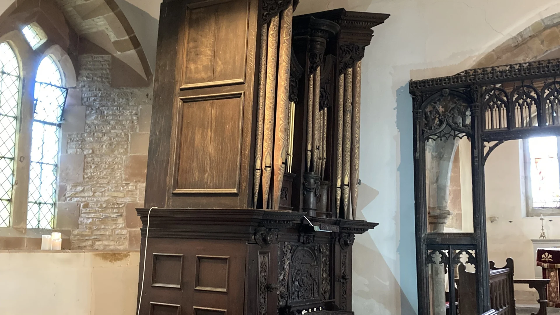 Carved wooden organ case  and pipes in nave
