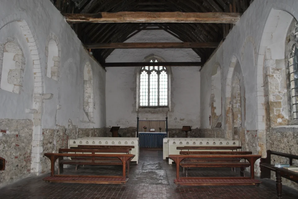Rustic and Partially Plastered Interior white painted pews and wooden crossbeams