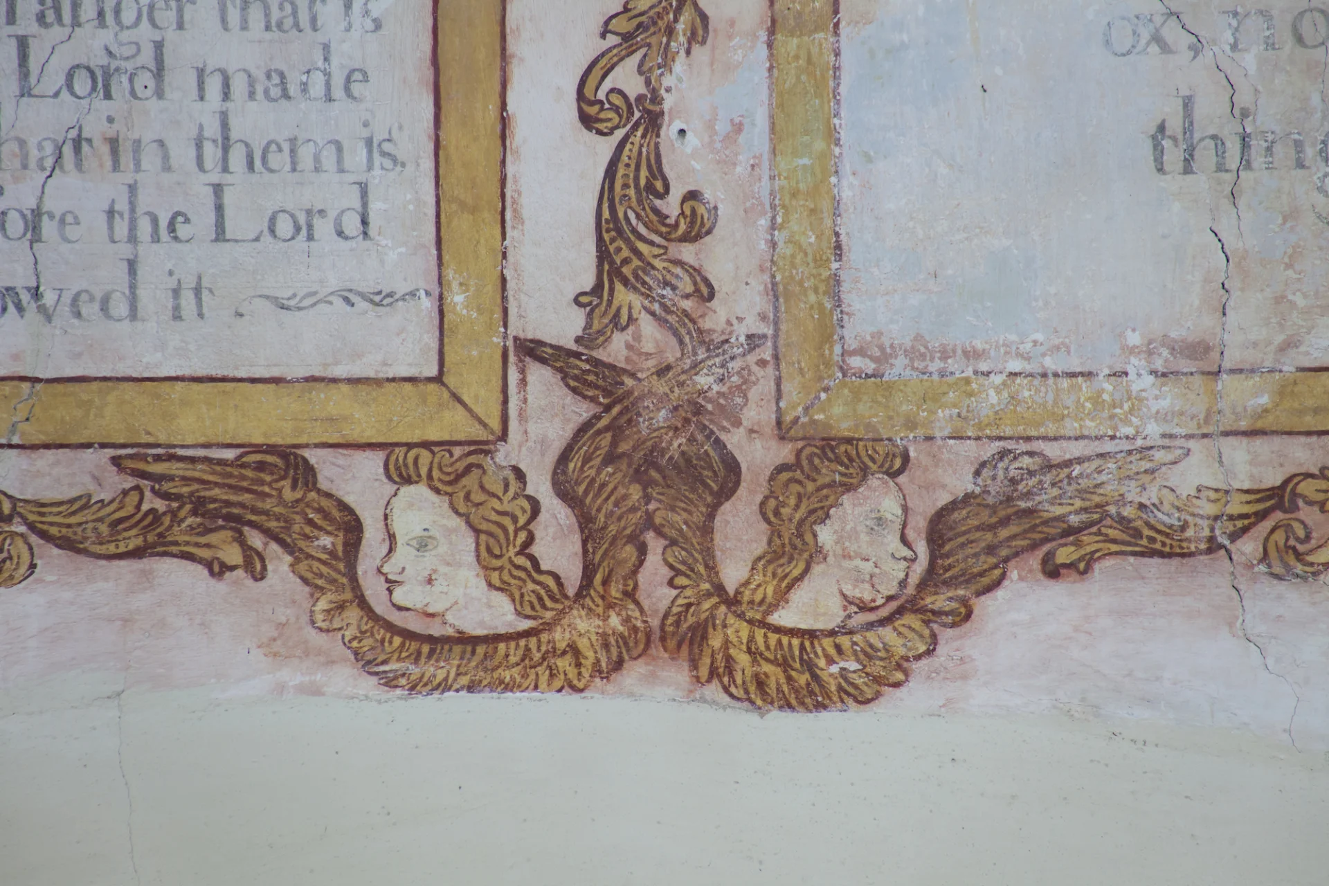 fine early seventeenth-century wallpaintings showing the Ten Commandments over the chancel arch, framed in twining leaves with enchanting cherubs; faces peering out.