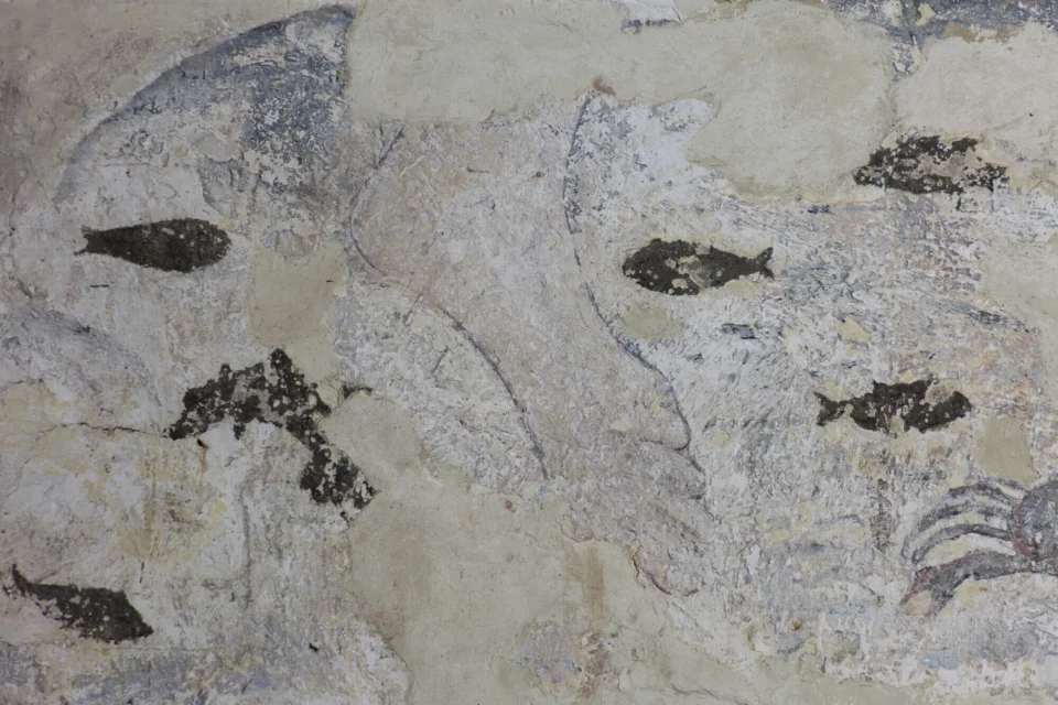 Partially surviving wall painting of St. Christopher's foot in a river surrounded by little black fish and a crab.