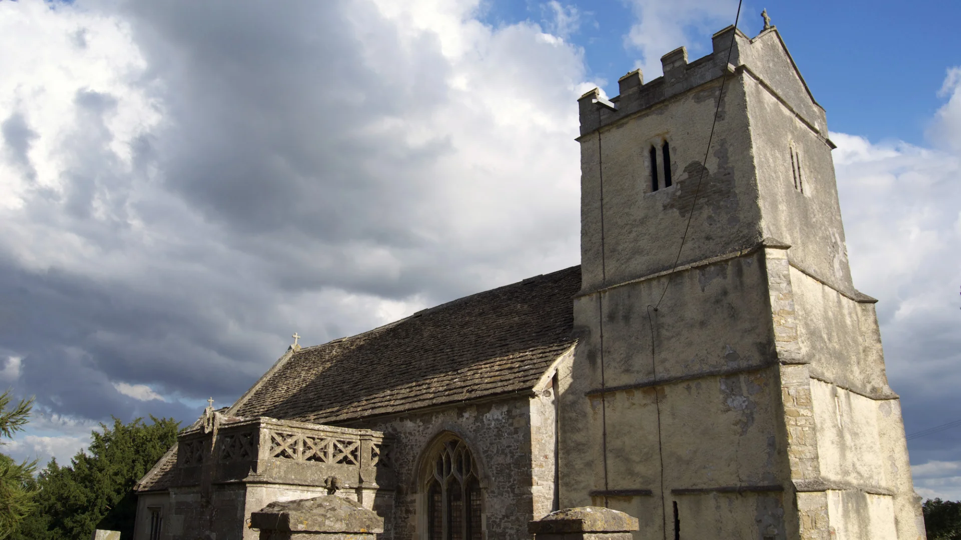 External view of stone church with square tower