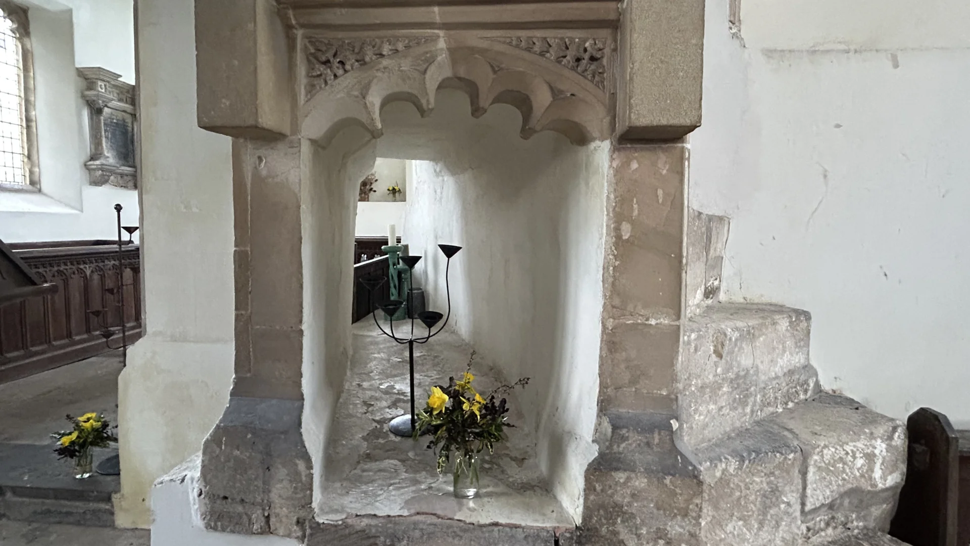 Squint at St James Church Charfield with a vase of yellow flowers in the center