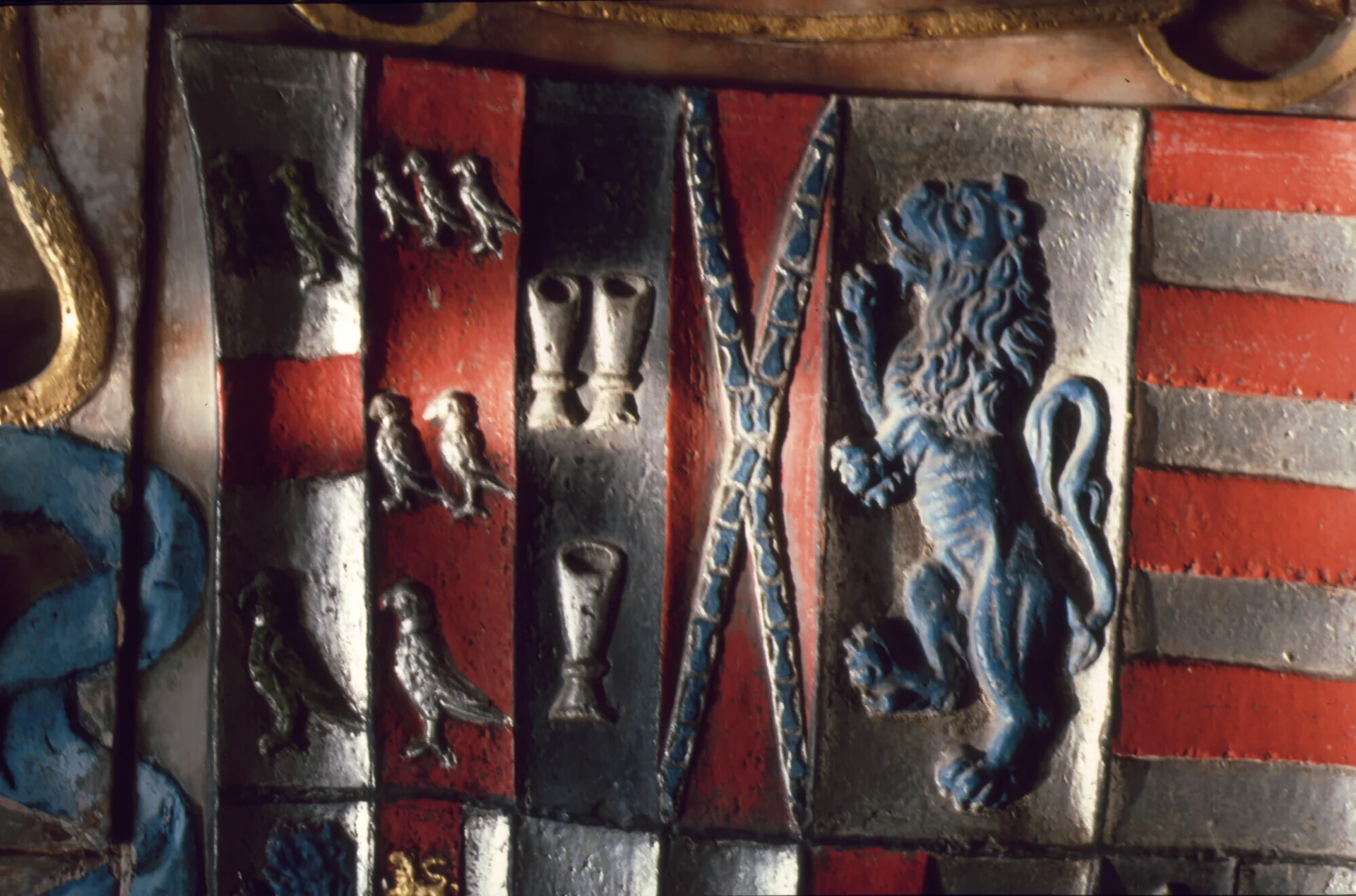 Colourful Arms showing several silver parrots on red ground and a blue lion rampant on silver ground.