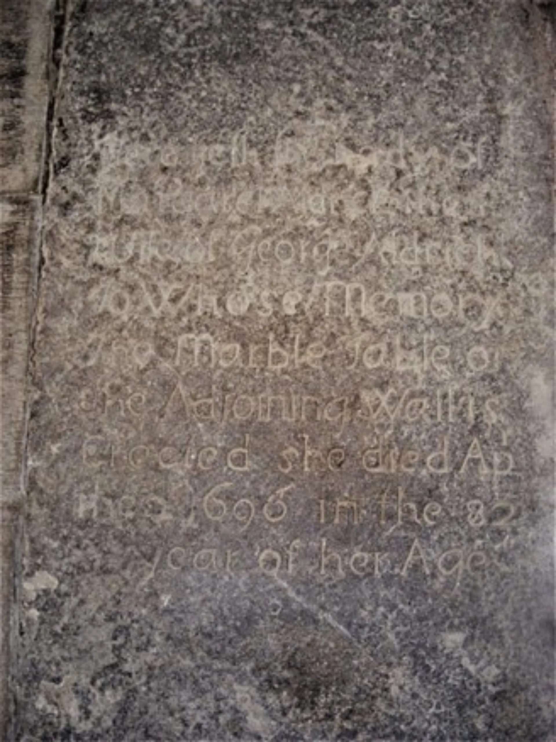 Margaret Aldritch's faded grave with basic inscription on dark stone.