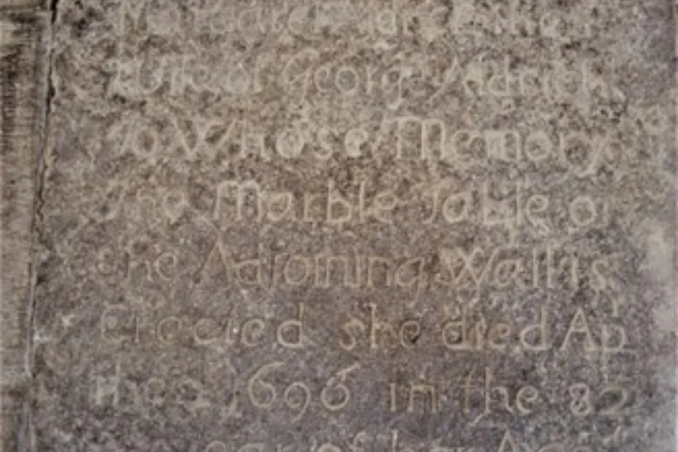 Margaret Aldritch's faded grave with basic inscription on dark stone.