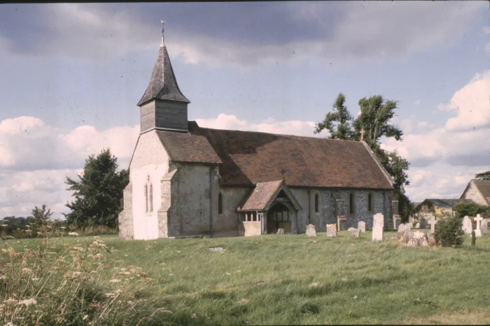 Church exterior with tall bell tower and red slanted roof