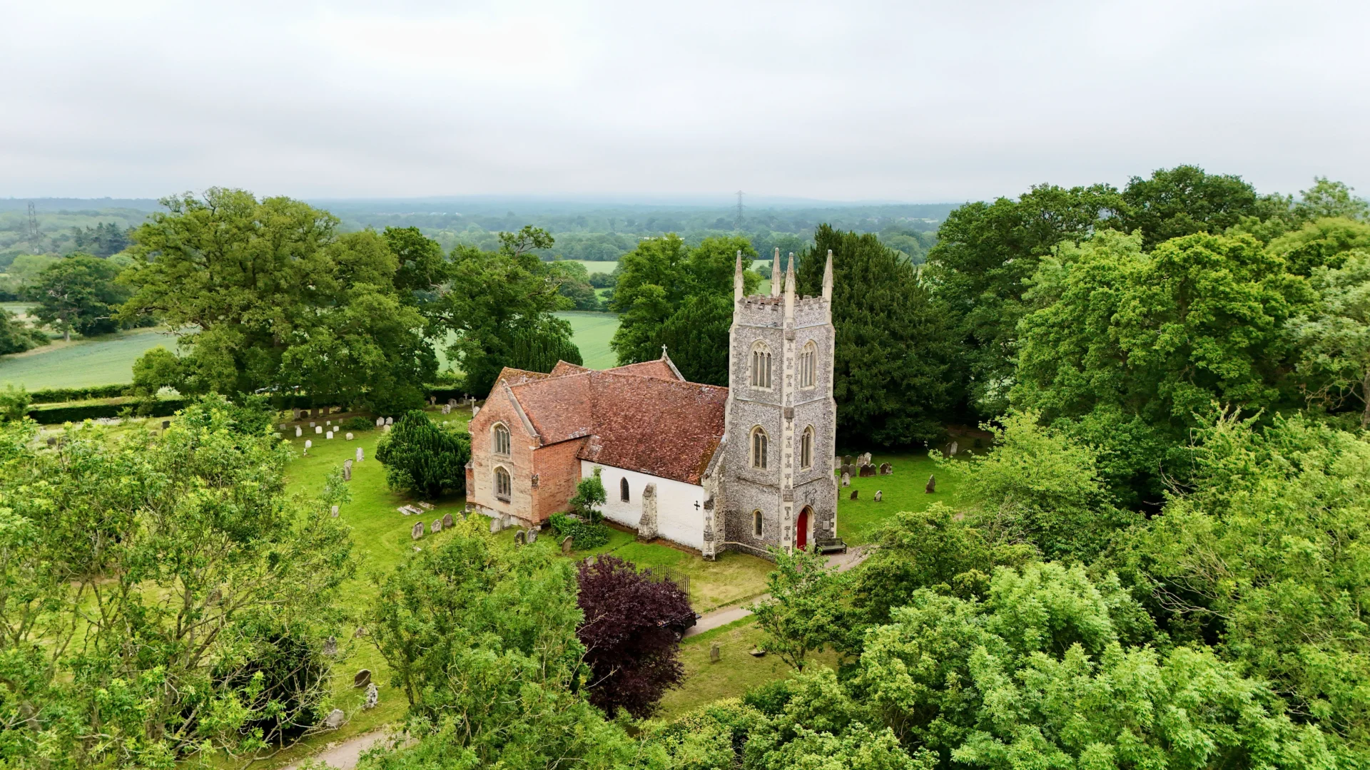 St Marys Hartley Wintney drone photograph in misty landscape scene