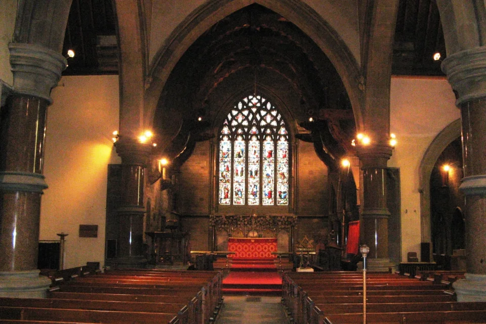 Interior view, large stained glass windows, marble columns holding stone arches