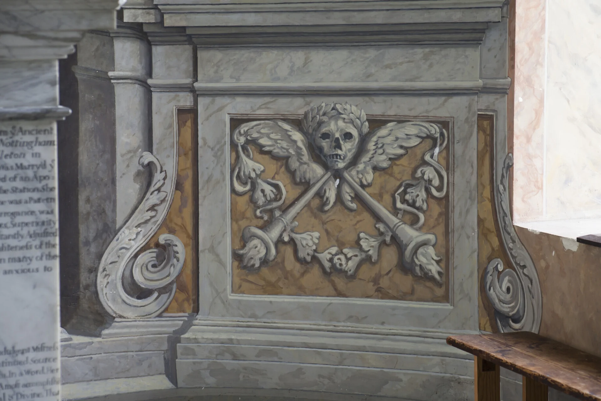 Illusionistic painting of a memento mori skull, made to look as if carved in marble.