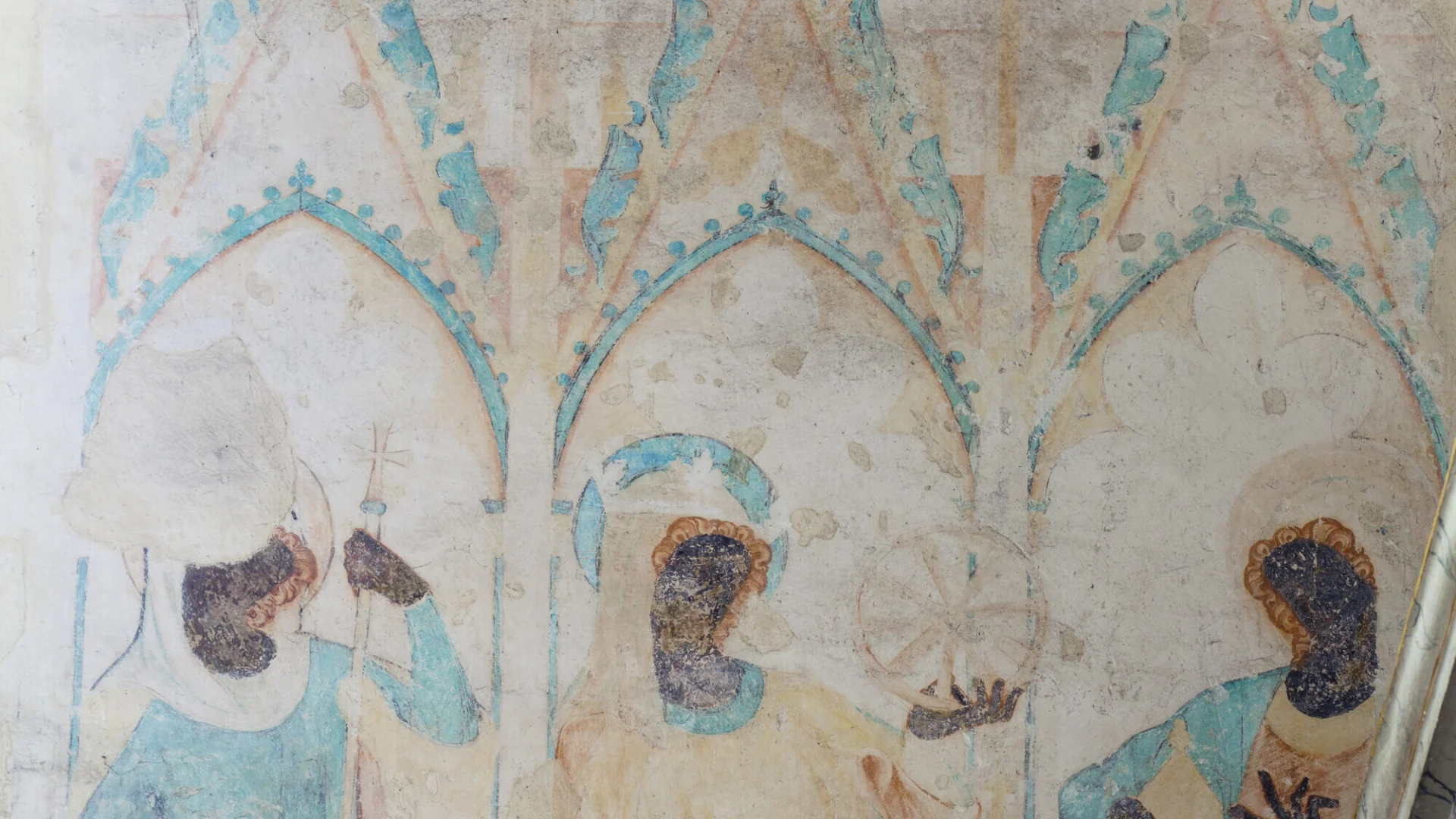 three figures wear colourful clothing and are playing instruments - in a wall painting