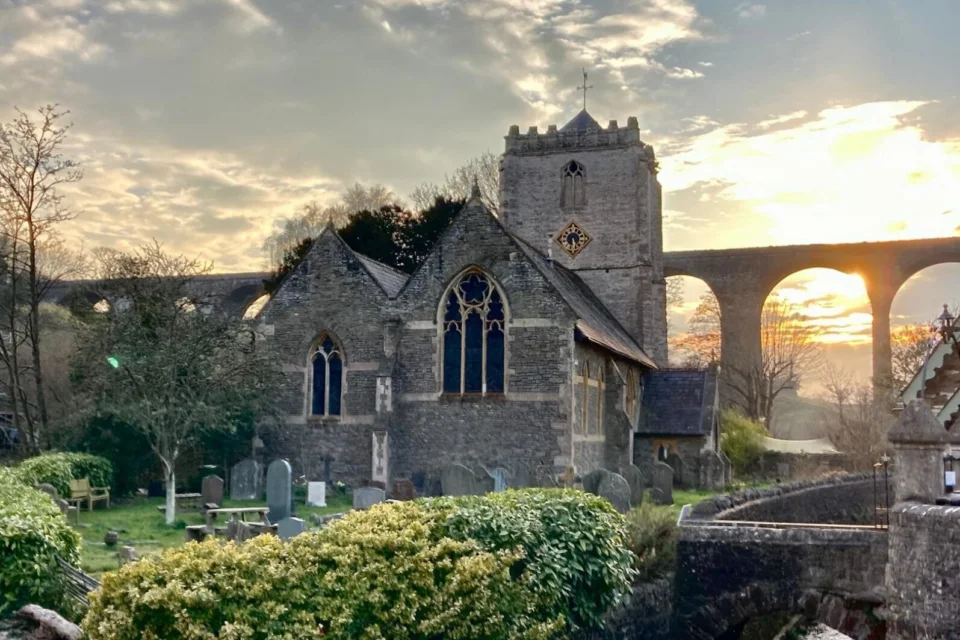 The Church of Thomas a Becket and Pensford Viaduct against the setting sun