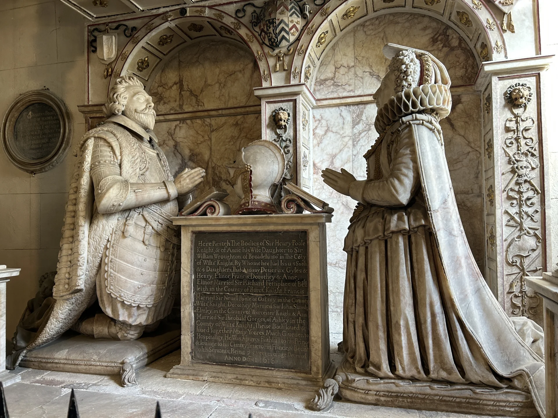 A 1616 stunning stone tomb showing a man and woman in period dress kneeling and facing each other praying.