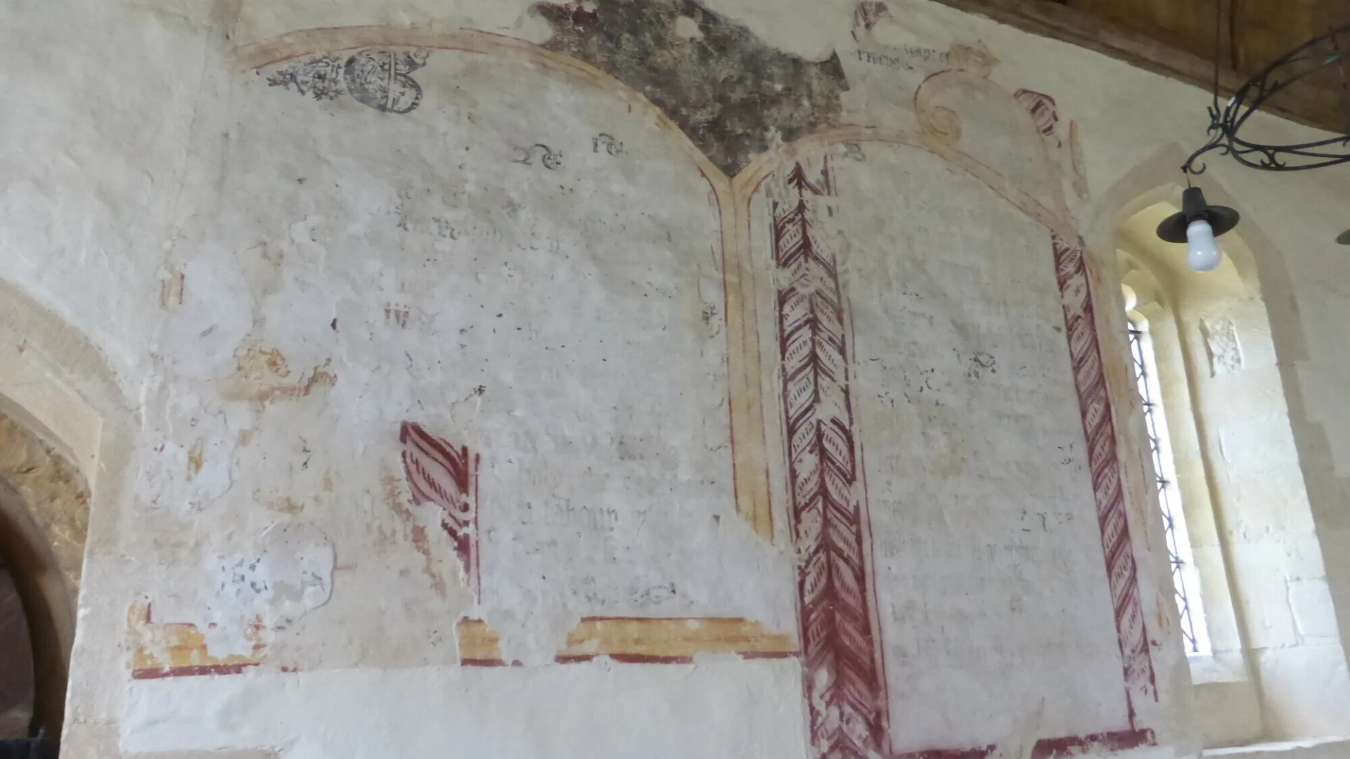 A large wall inside the church shows some beautiful yellow and red wall paintings.