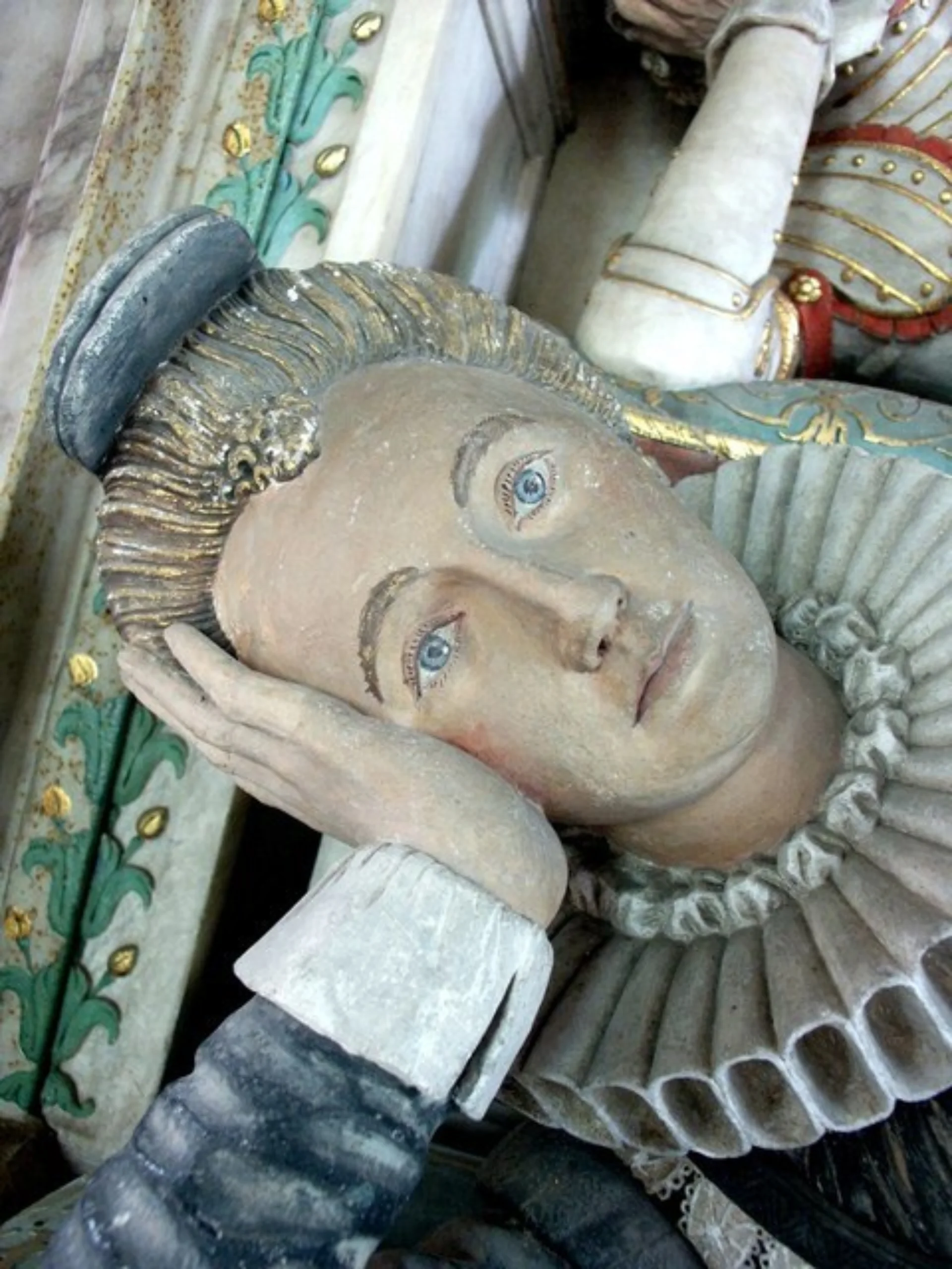 Close up of Frances Wray's effigy, showing her head resting on her hand, blonde hair and blue eyes, serious expression, Jacobean white ruff.