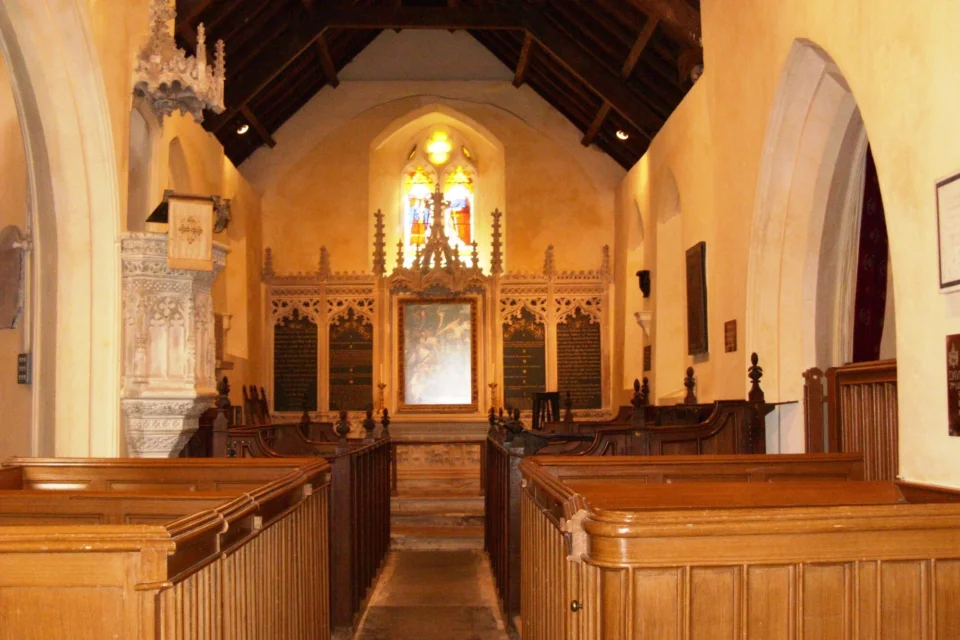 Interior view showing box pews, stone pulpit and wooden altar and stained glass