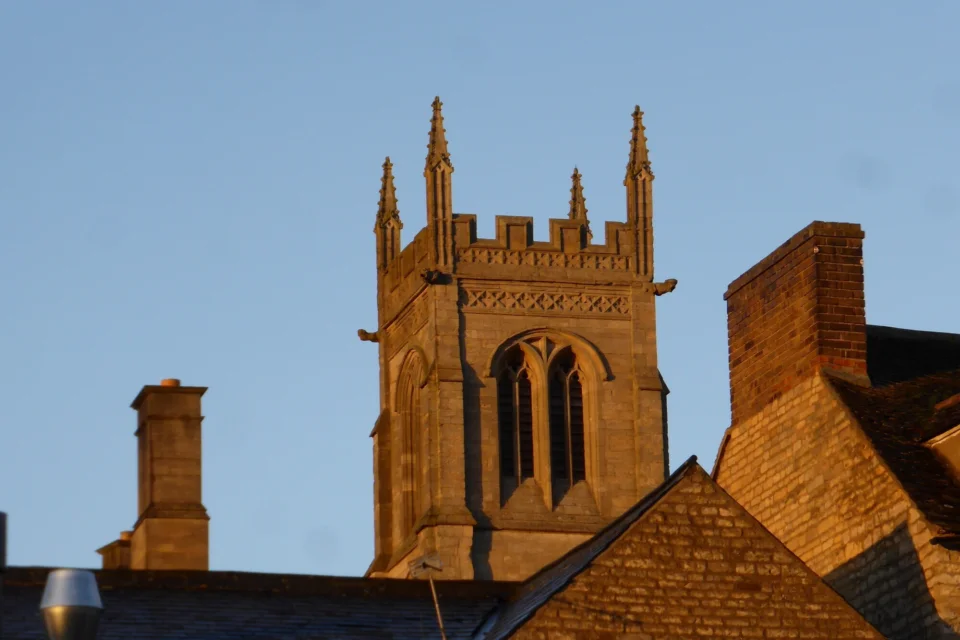 The tower of the church viewed among other building's roofs