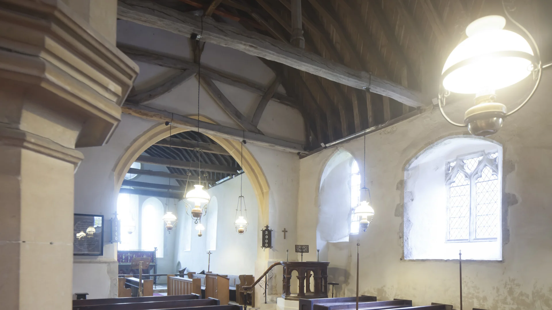 The interior of the church with its pews and natural light pouring through the windows