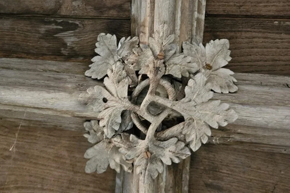 Close up image of wooden ceiling with delicately carved vine leaves in a roundel shape