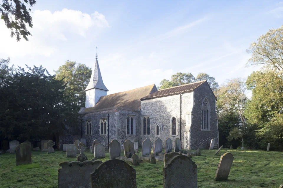 Exterior image of the church with its flint walls among nature