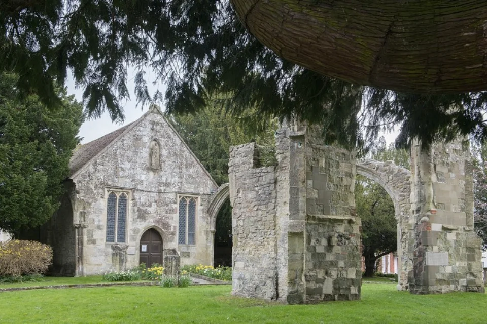 Exterior of the grey stone built church viewed from the garden