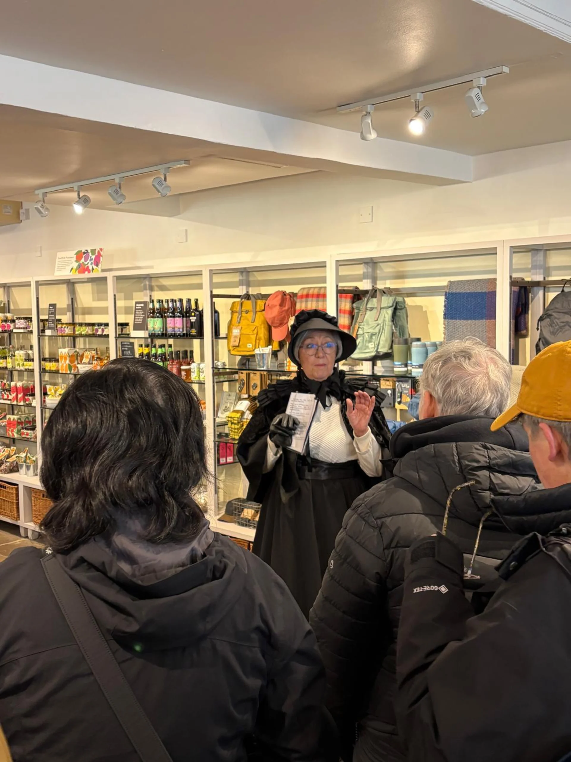 A woman in historic dress addressing a tour group.