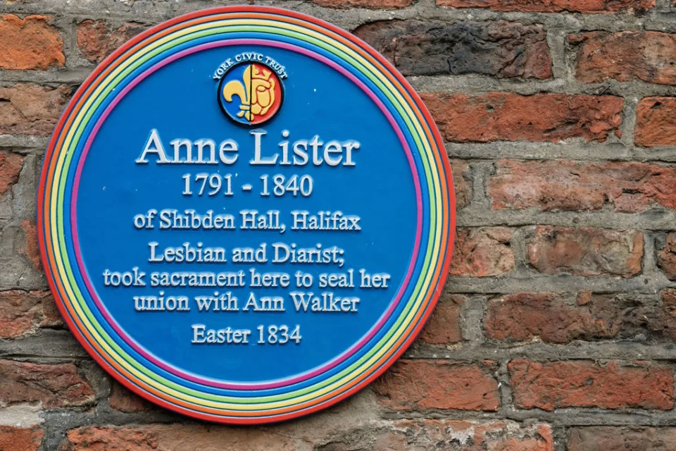 Blue plaque with a rainbow coloured edge recording the visit of Anne Lister and Ann Walker in 1834
