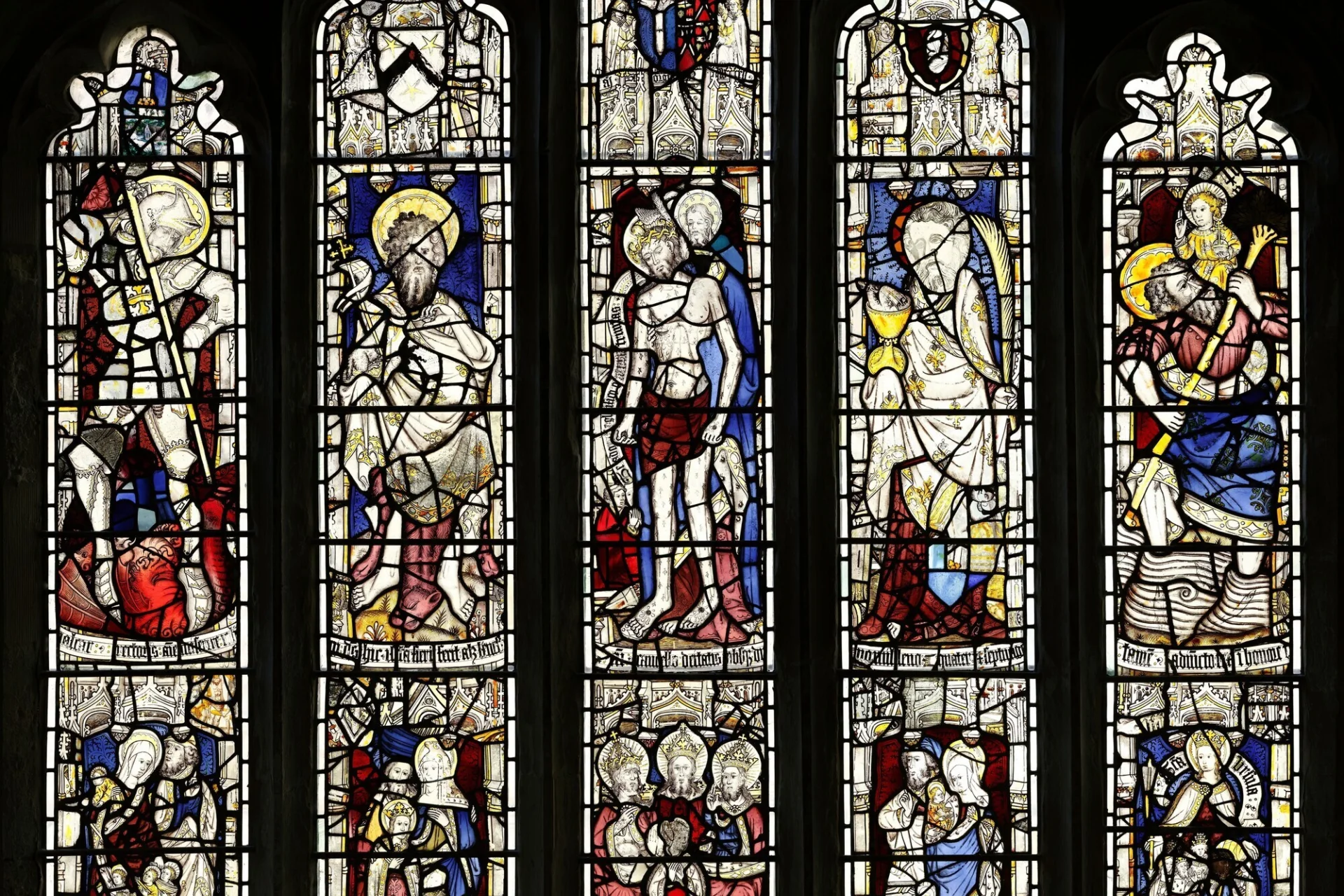 Five stained glass window panels depicting biblical passages