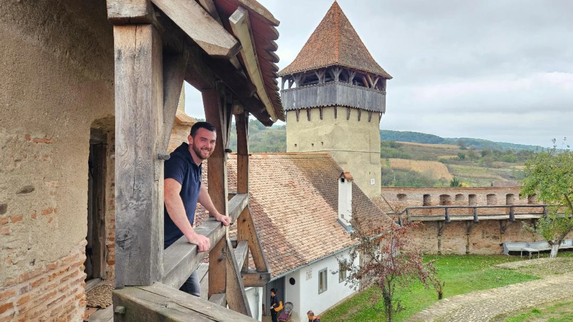 Guest speaker, Daniel Richards, standing on the balcony of the restored site of Alma Vii citadel in Transylvannia.