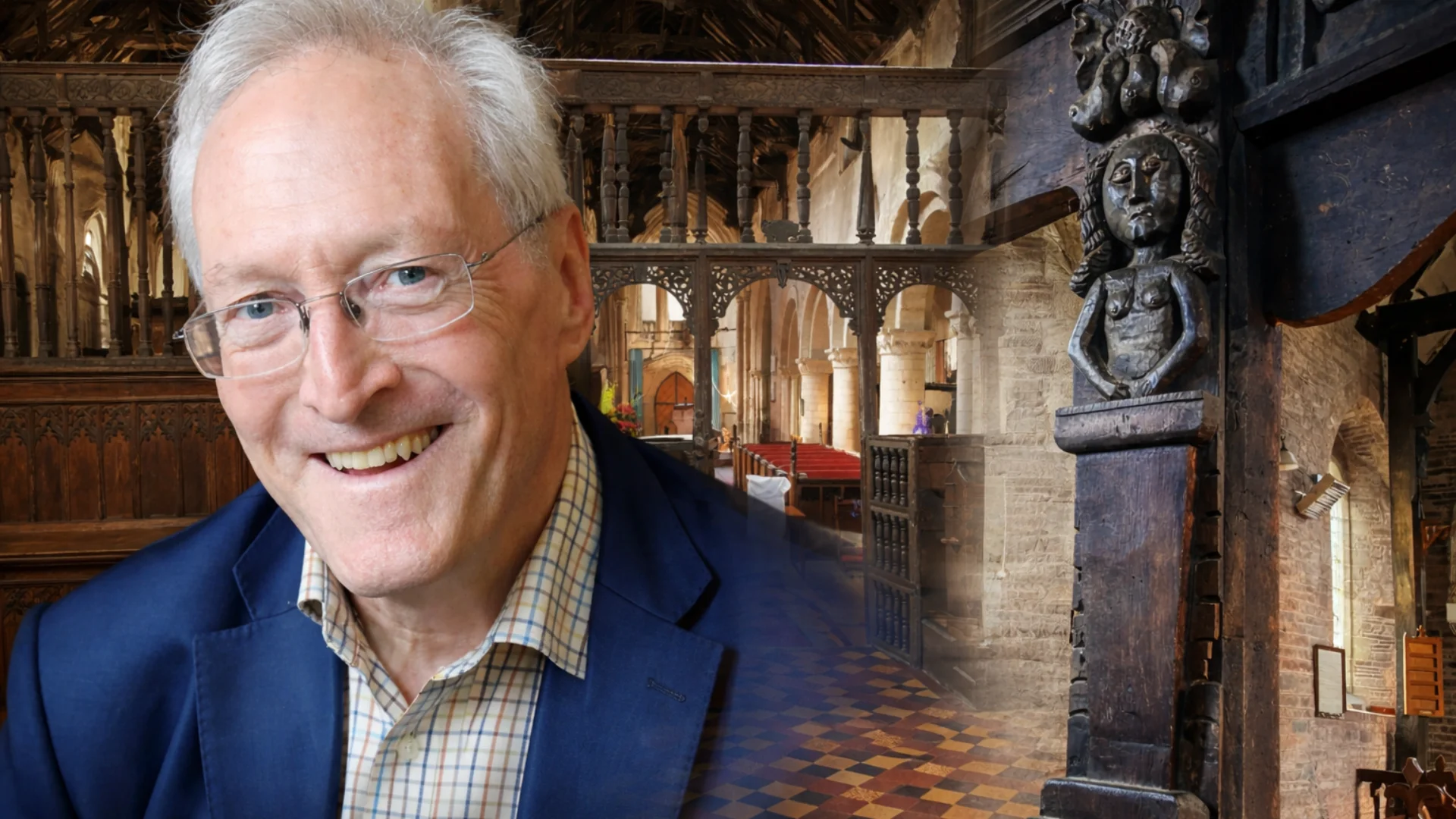 Headshot of Diarmaid in a navy suit jacket and glasses, with a historic church screen behind, detailed wooden carving.