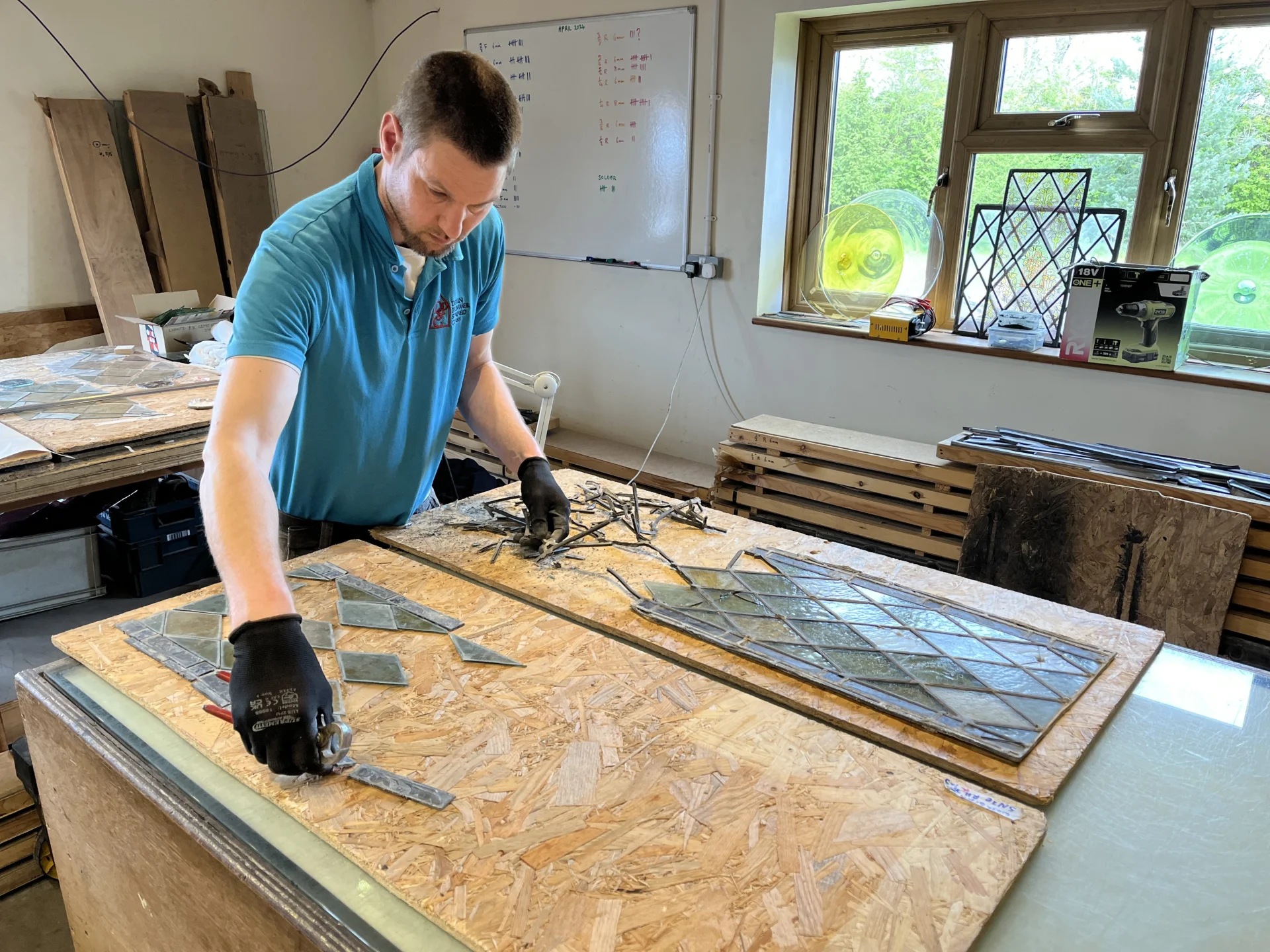 Specialist conservators working on vandalised window from St Mary's Church in Washbrook