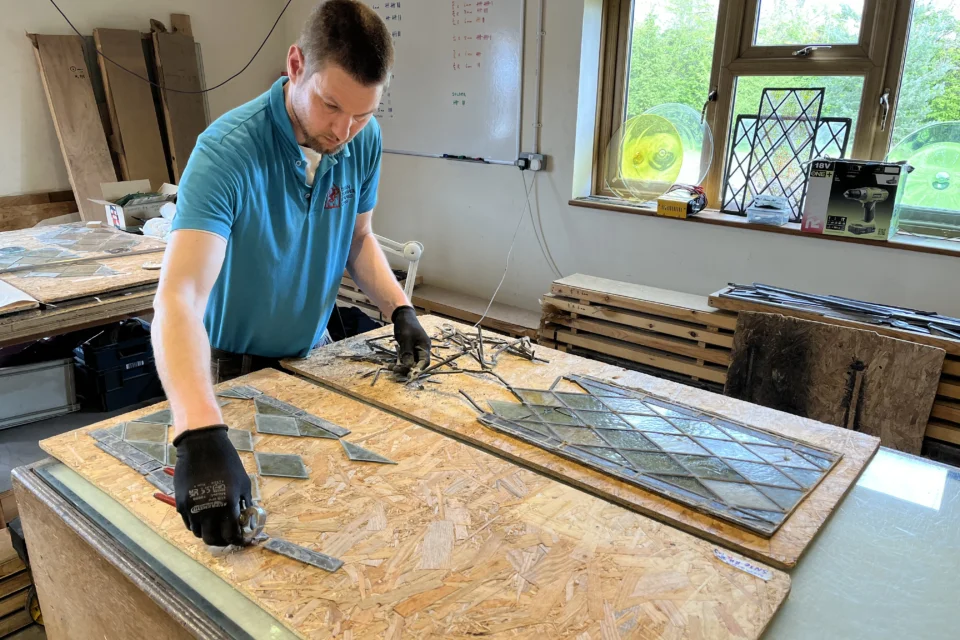 Specialist conservators working on vandalised window from St Mary's Church in Washbrook