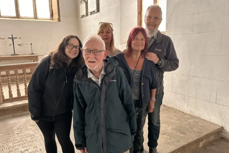 5 people from the Friends of Wolfhampcote posing for a photograph inside Wolfhampcote church