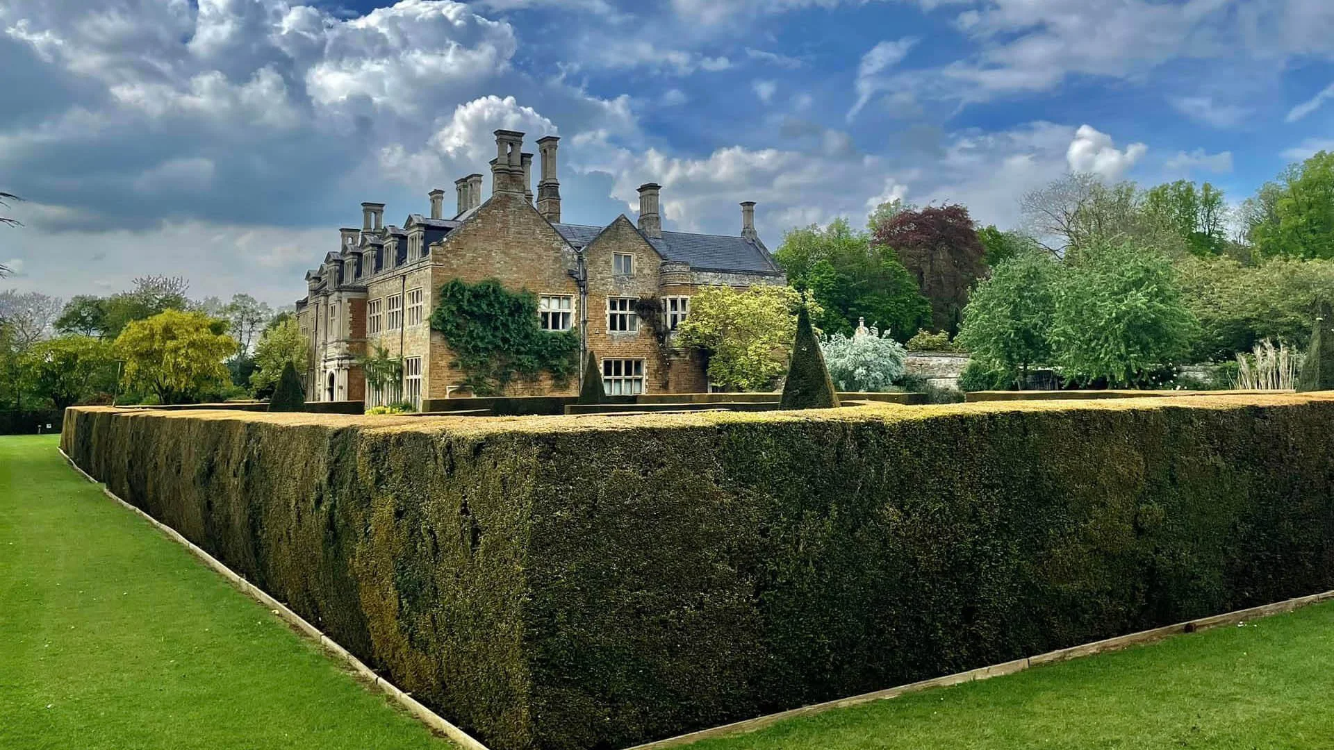 Yellow stone Elizabethan manor house with blue skies