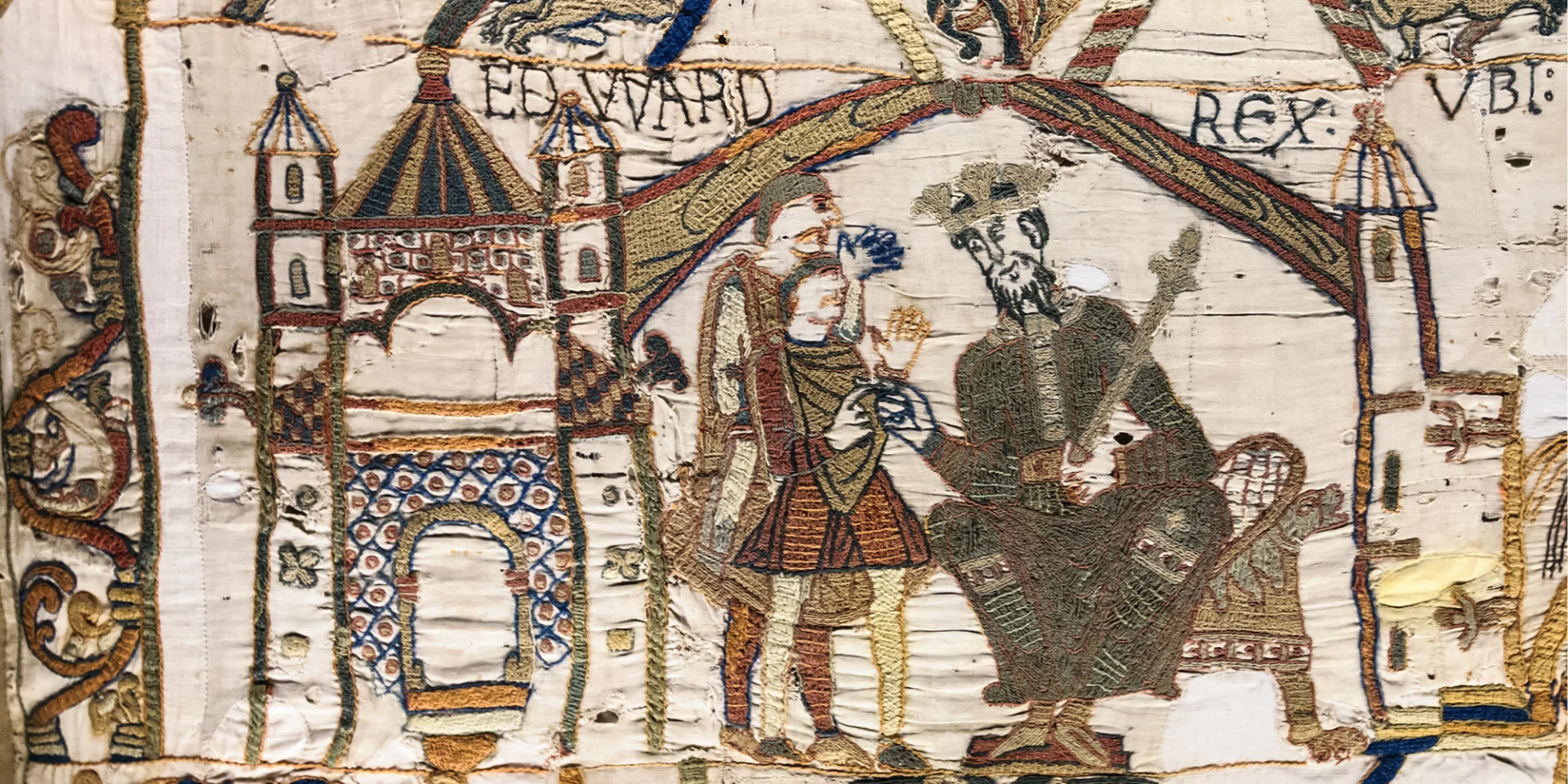 Embroidery showing Edward the Confessor seated on a throne inside a castle.