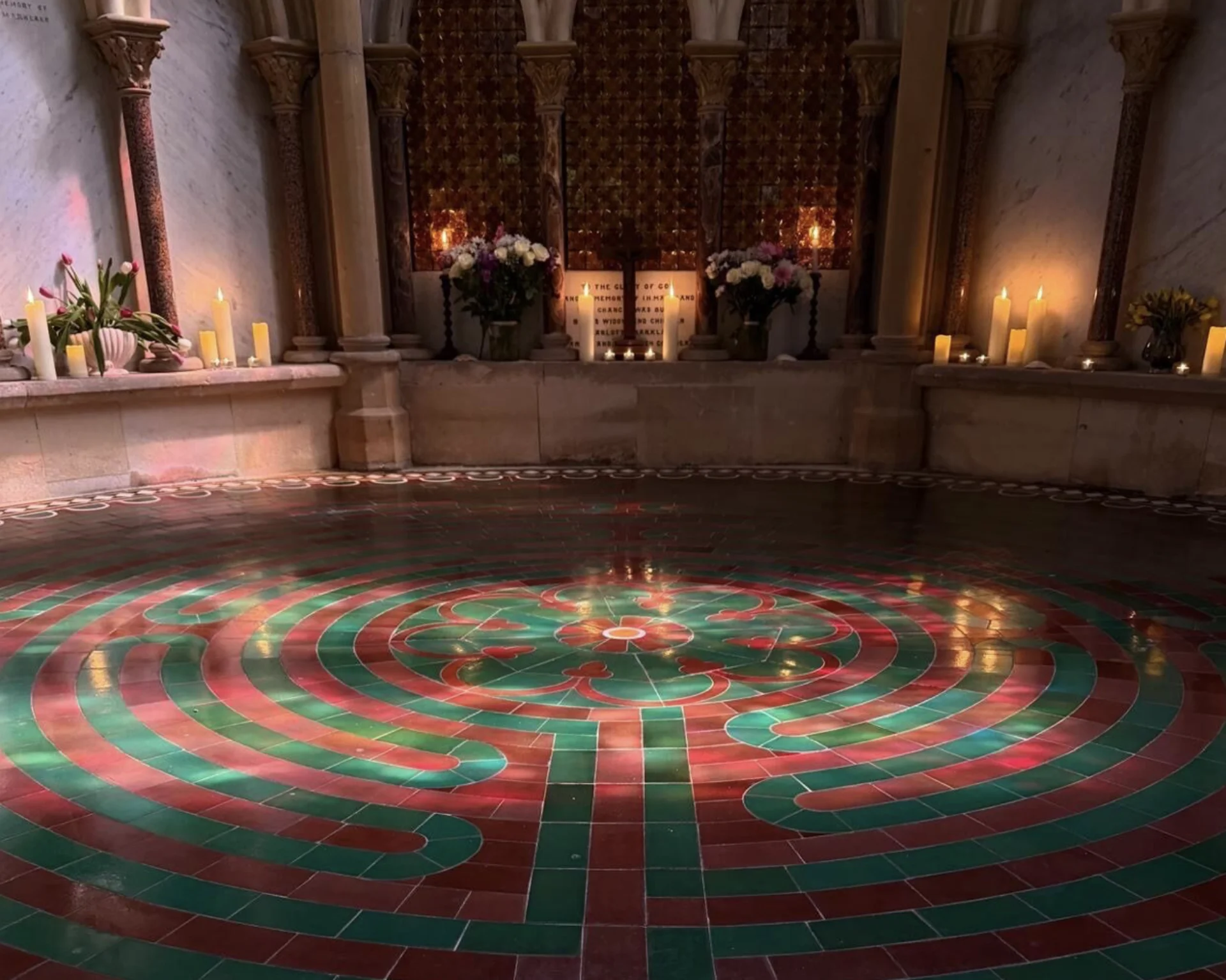 Labyrinth surrounded by candles and lit up with sunlight form the windows.