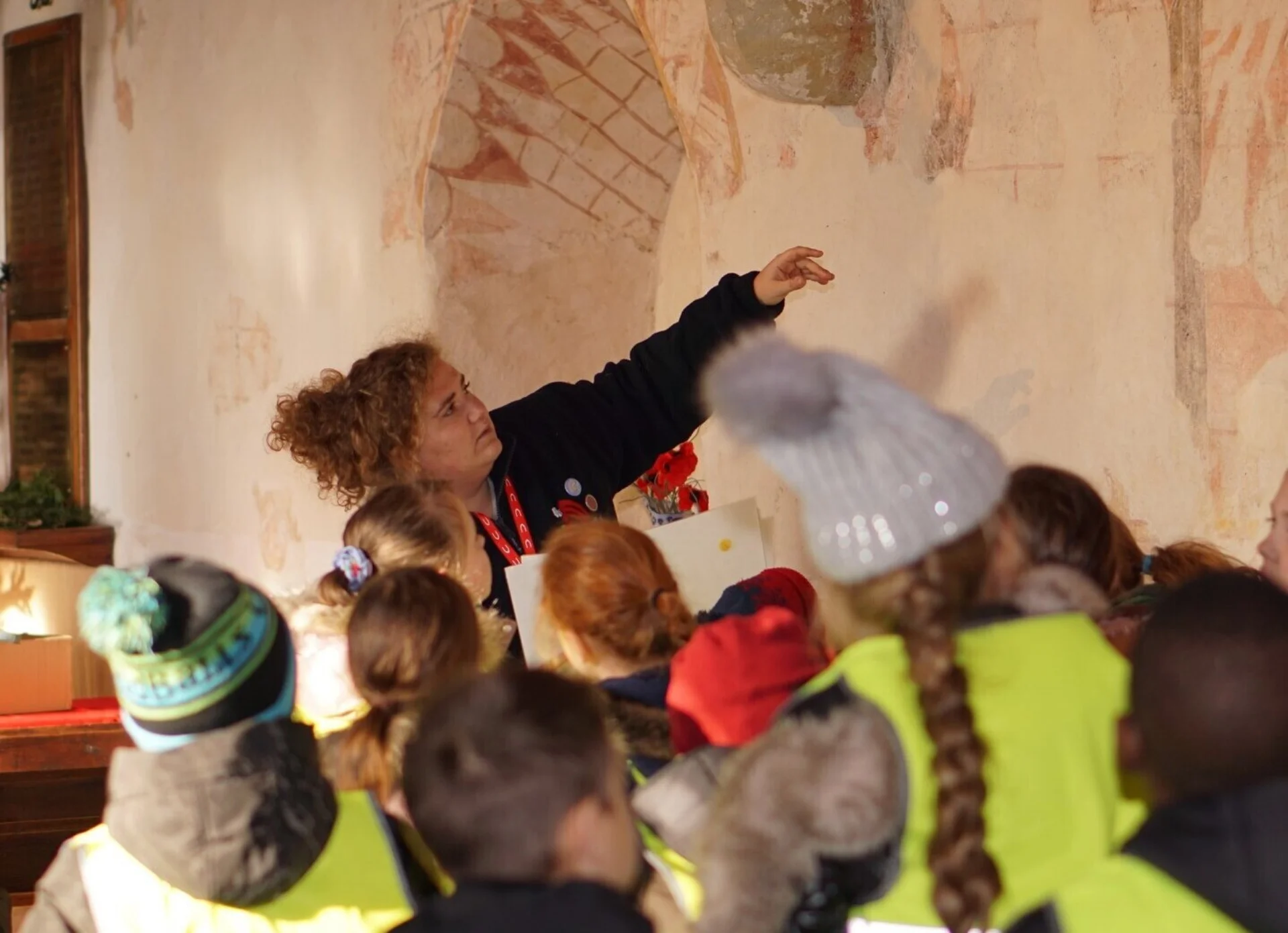 Children from the local school explore the wall paintings found in the Church of St Thomas a Becket in Capel, Kent.
