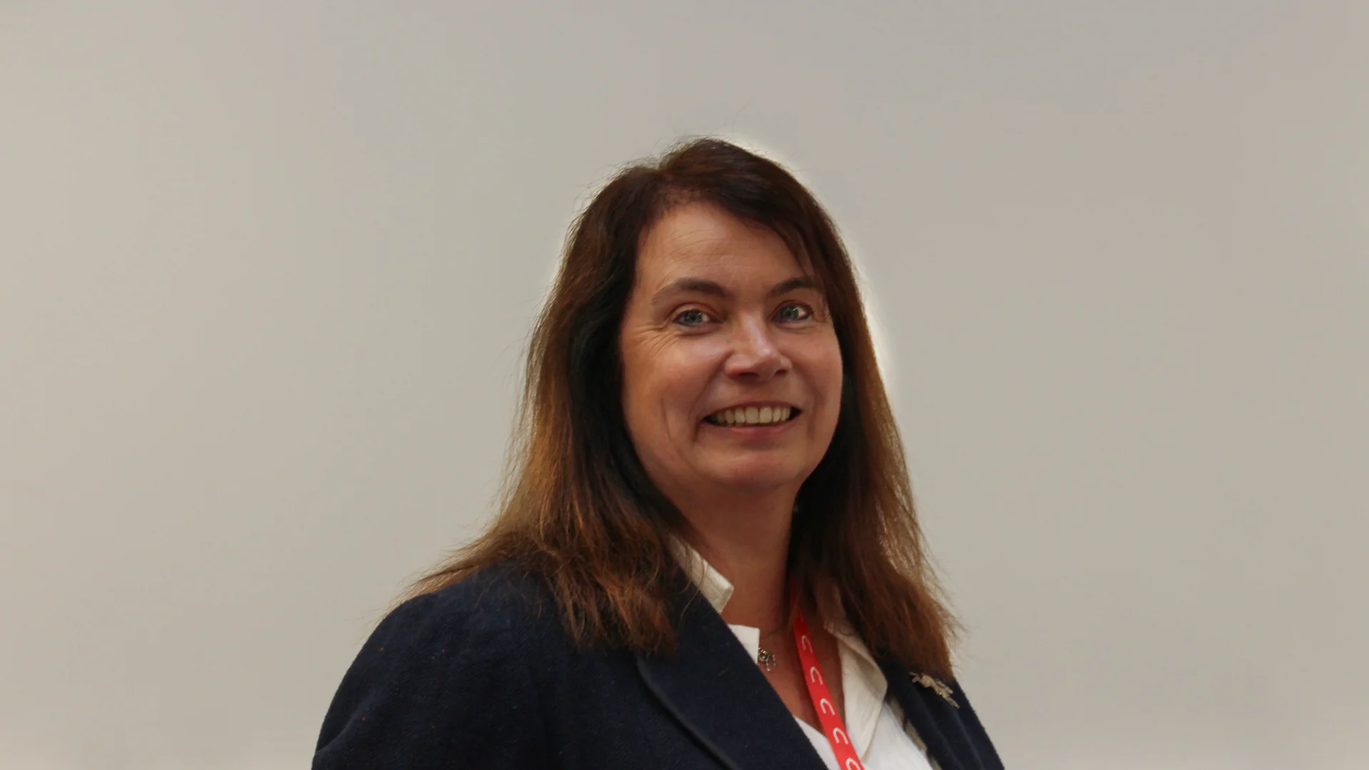 Portrait of Judith Patrick, Director of Operations in front of a beige wall