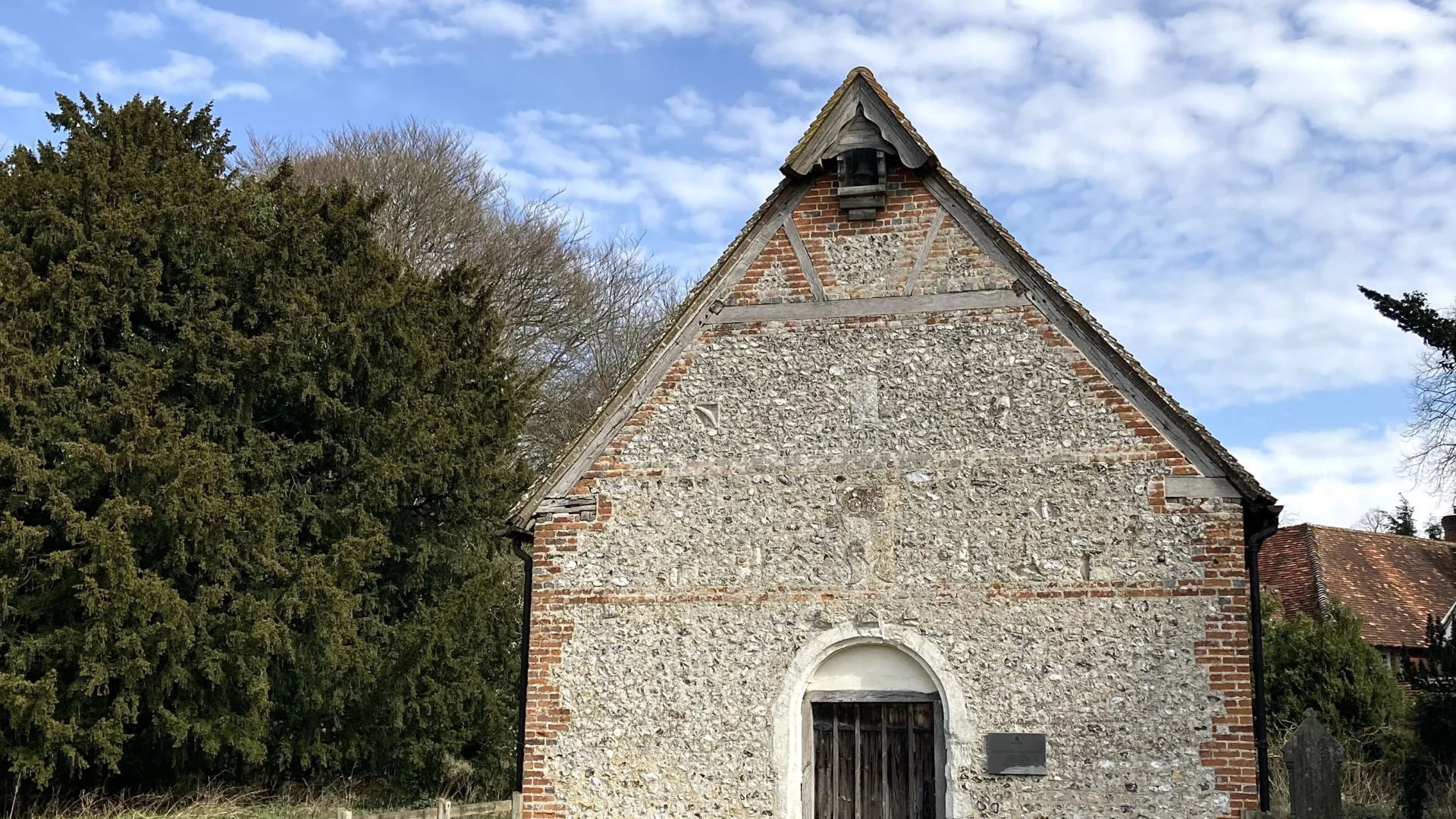 Exterior of the church built with flinted walls and red brick