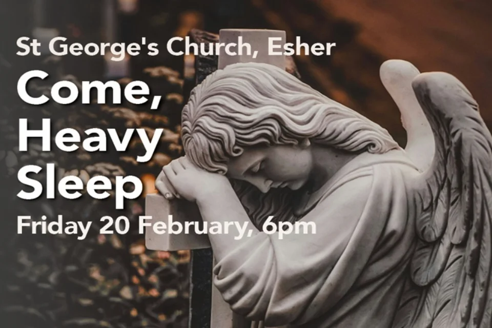 Statue of an angel leaning against a cross in white marble