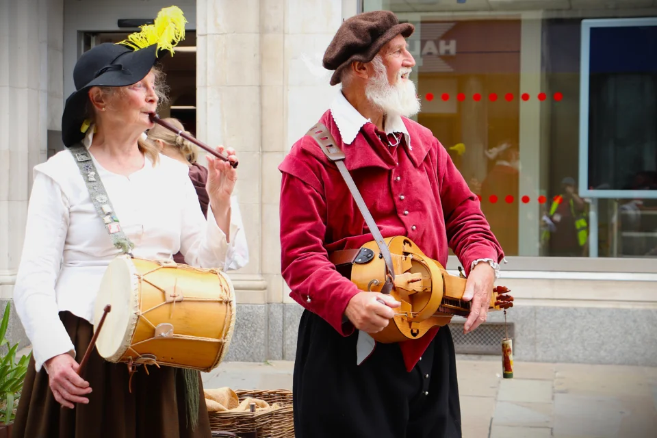 Two musicians in historical costume playing historical instruments