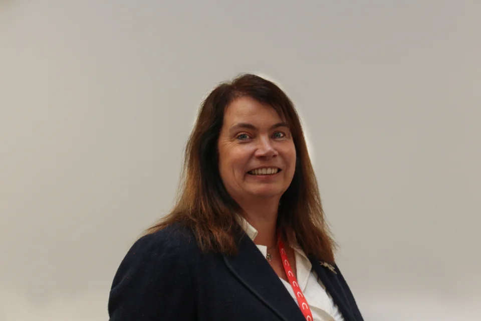 Portrait of Judith Patrick, Director of Operations in front of a beige wall