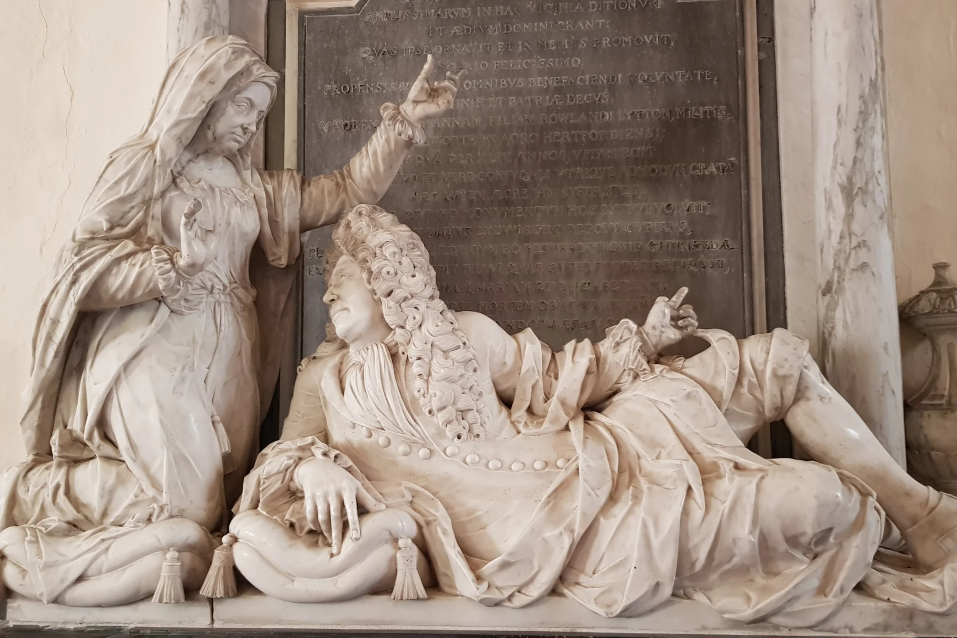 Marble statues of man reclining and woman above